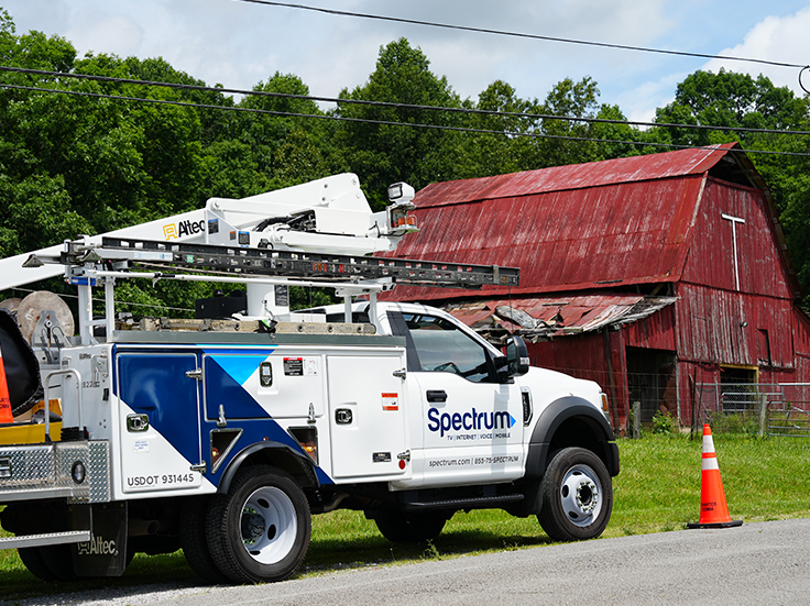 Spectrum bucket truck parked by an old barn in Pleasant Hill