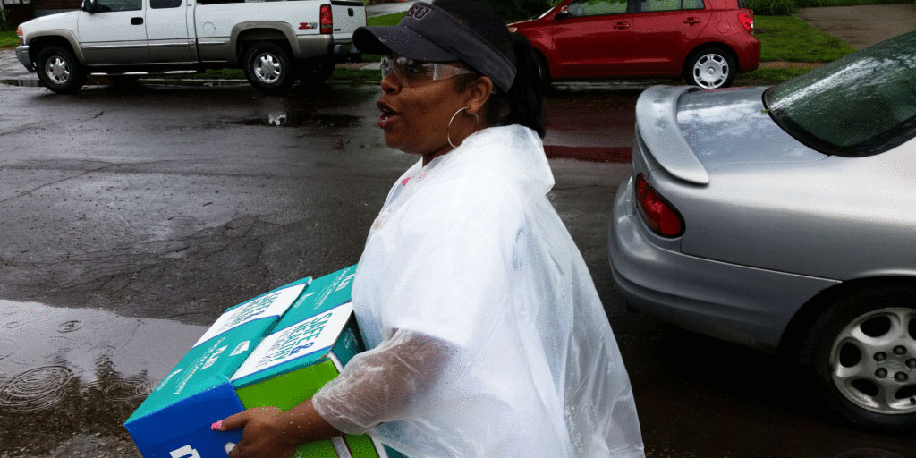 An image of a Charter volunteer distributing Safe & Healthy Home Kits on National Rebuilding Day.