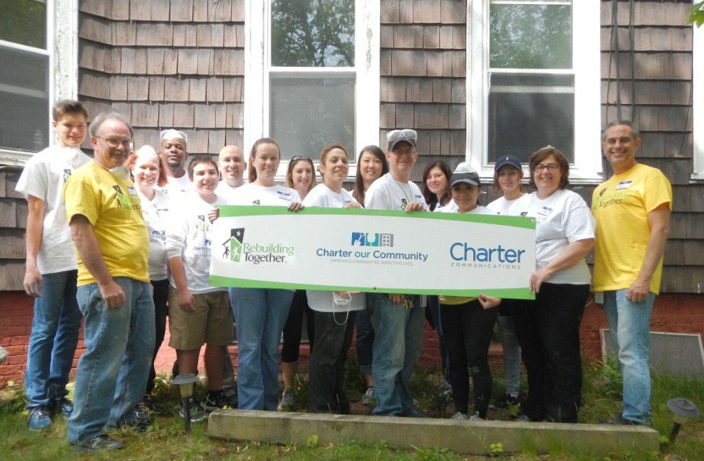 An image of volunteers in front of homes they rebuilt in Worcester, Massachusetts. 