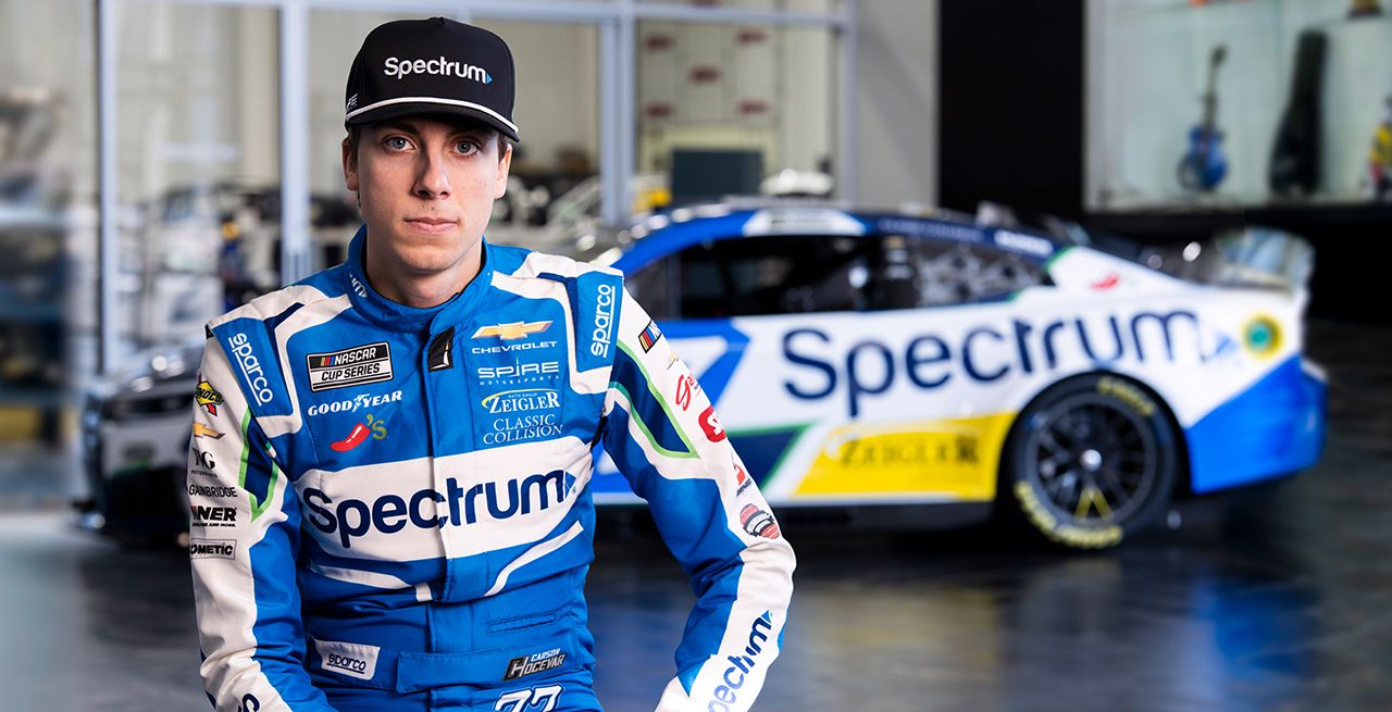 Carson Hocevar posing in front of the Spectrum car