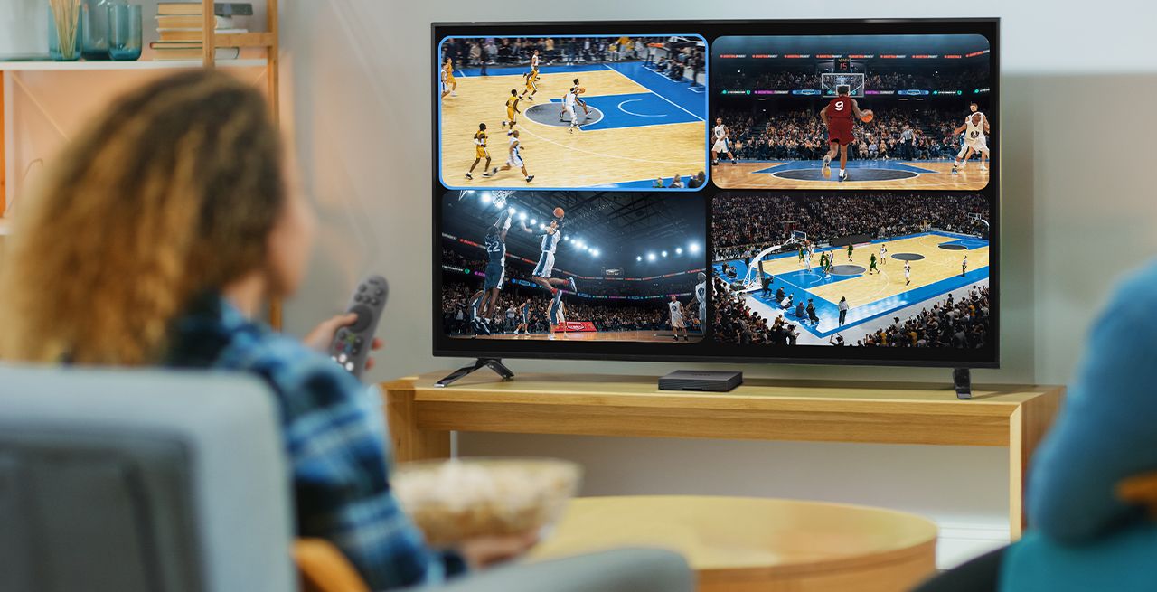 People watching TV sports programming in a living room viewed from behind