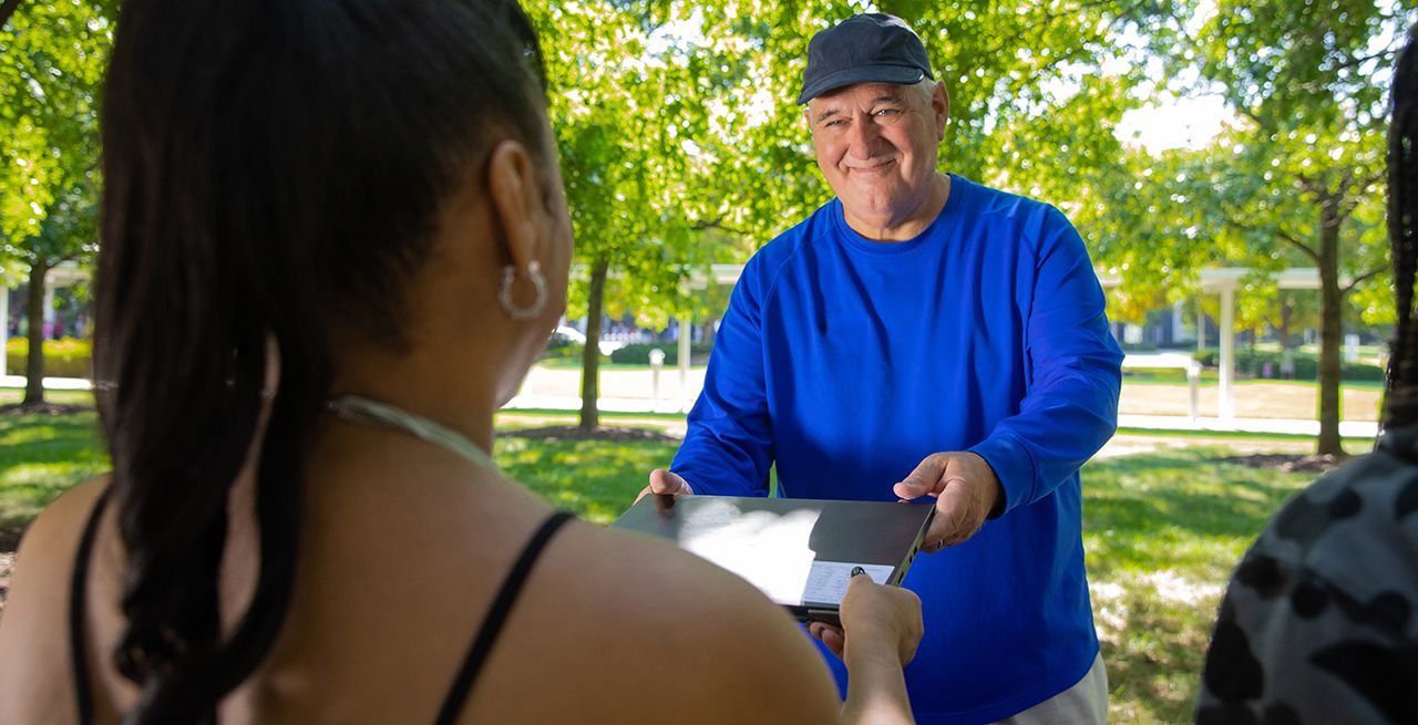 A Spectrum Community Impact volunteer handing out laptops