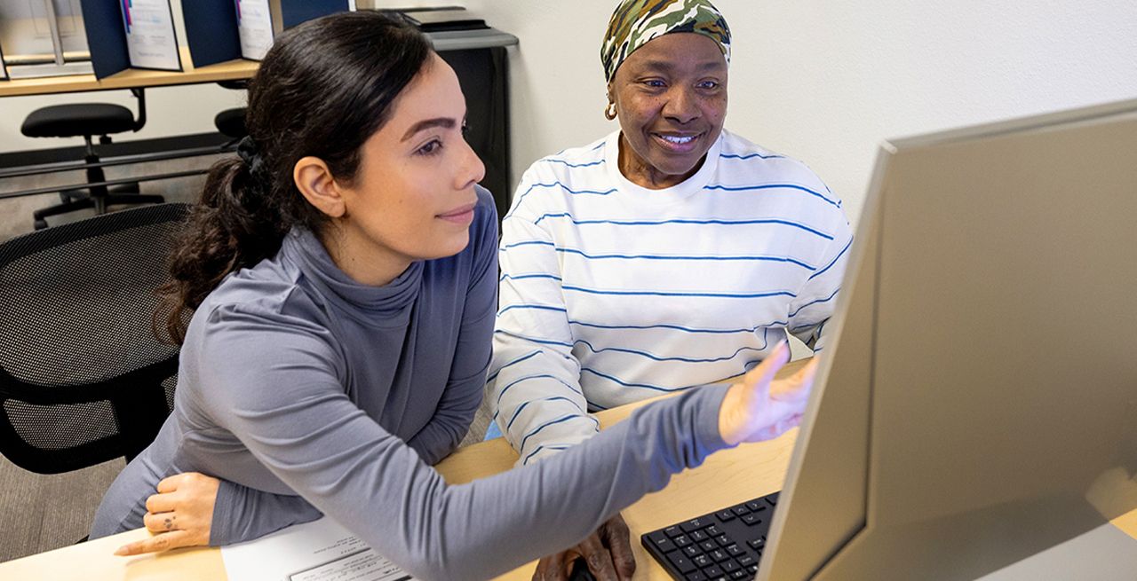 An adult student getting instruction in a computer lab