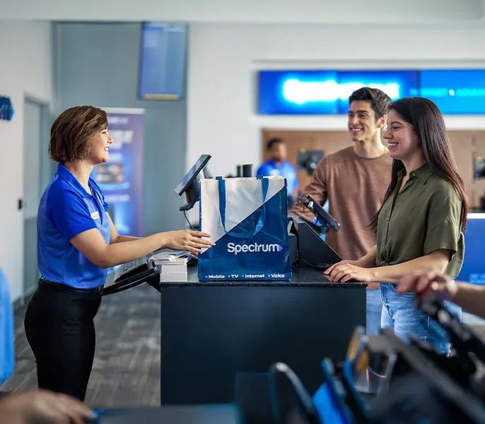 A rep assisting customers in a Spectrum Mobile store 
