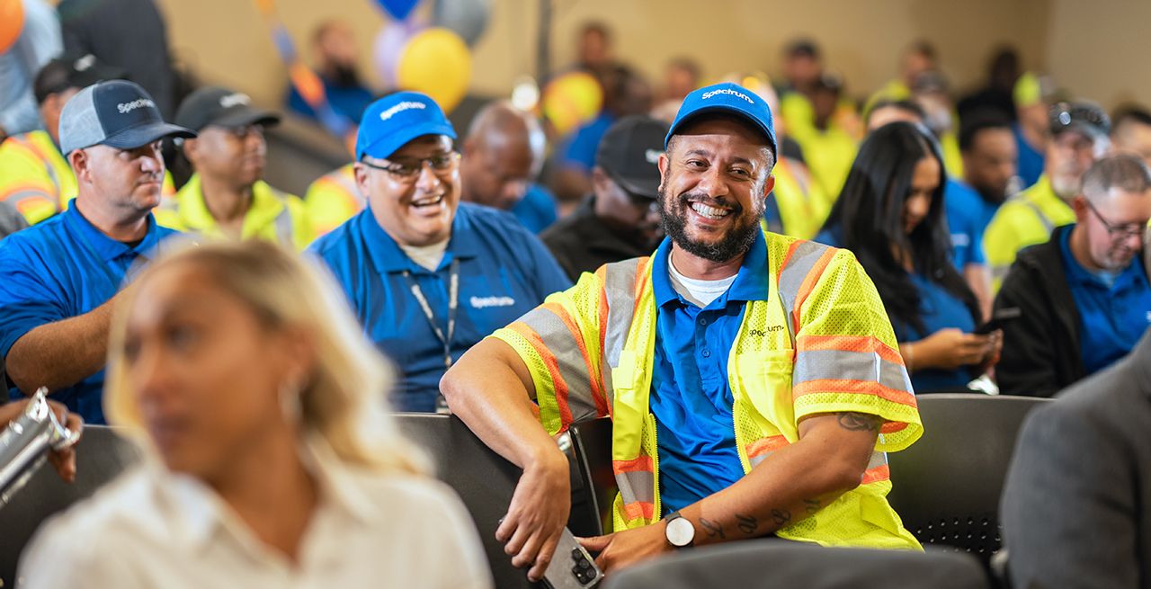 A Spectrum field technician laughs with his fellow employees at a training event