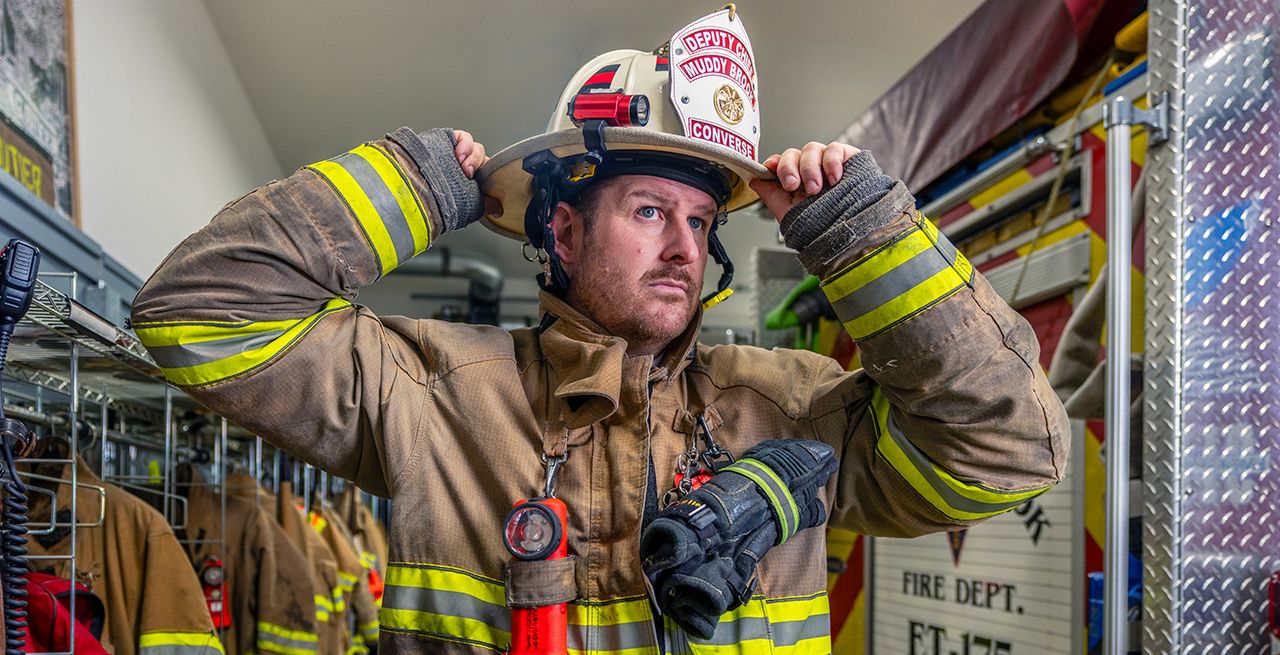 A fireman putting on his hat