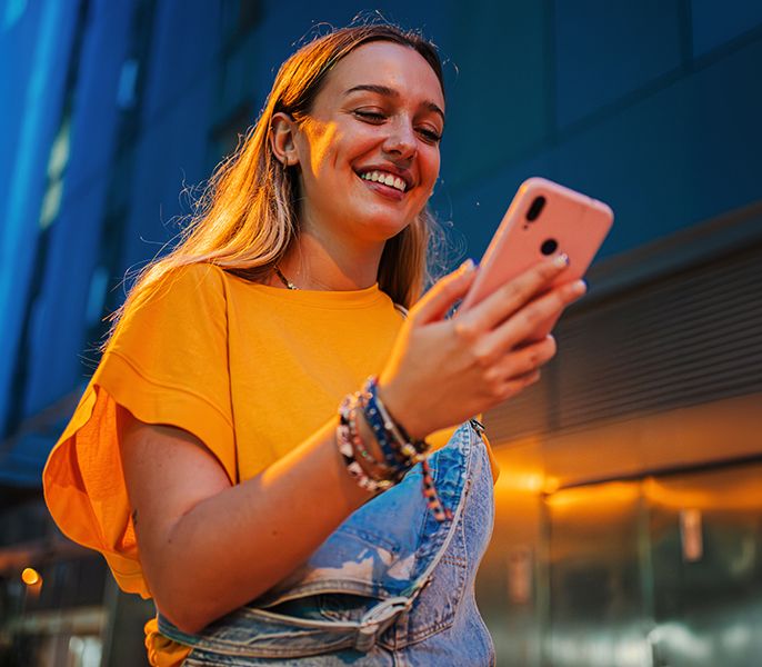 Woman using her smartphone, looking happy and satisfied