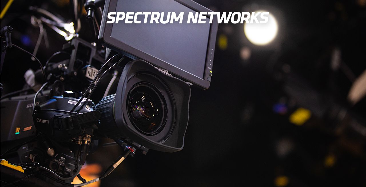 News camera in a Spectrum Networks studio with Spectrum Networks logo