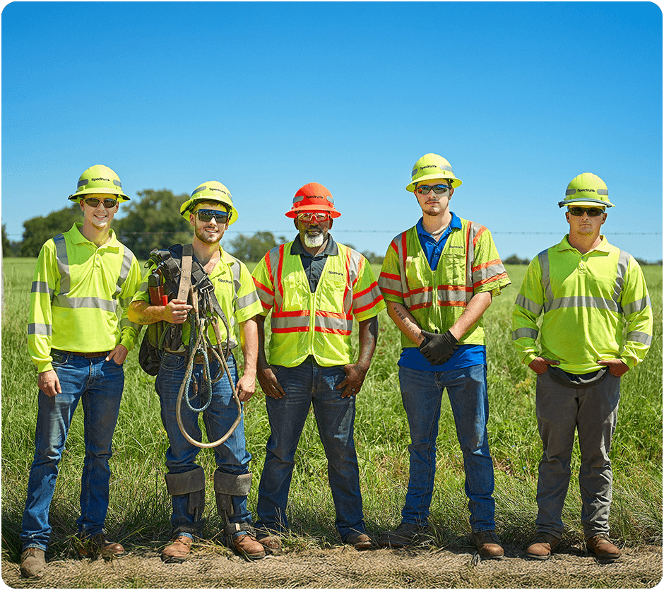 Spectrum field technicians pose with their vests, hard hats and gear on
