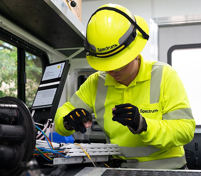 Spectrum field technician splicing fiber in her truck