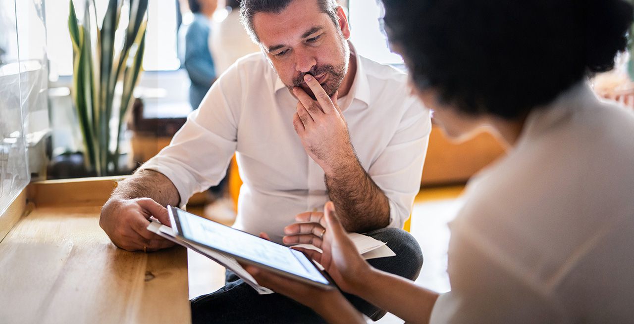 A small business owner meeting with a consultant looking at documents