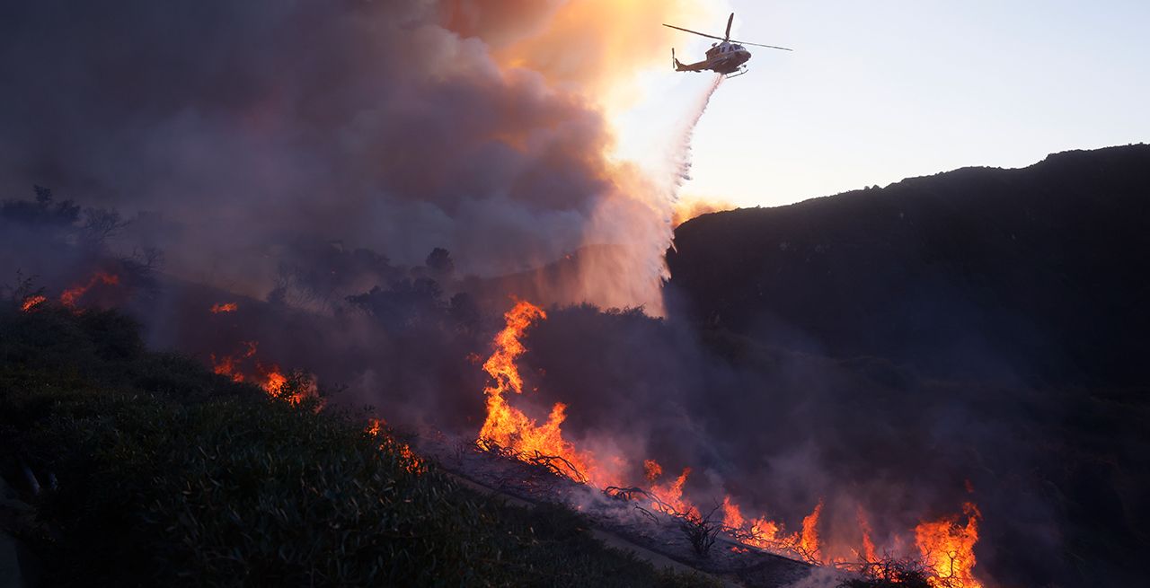 A helicopter drops chemicals on a wildfire in Southern California