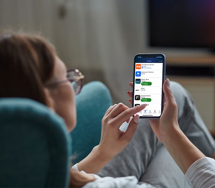 Someone using their mobile phone to view Spectrum Seamless Entertainment content