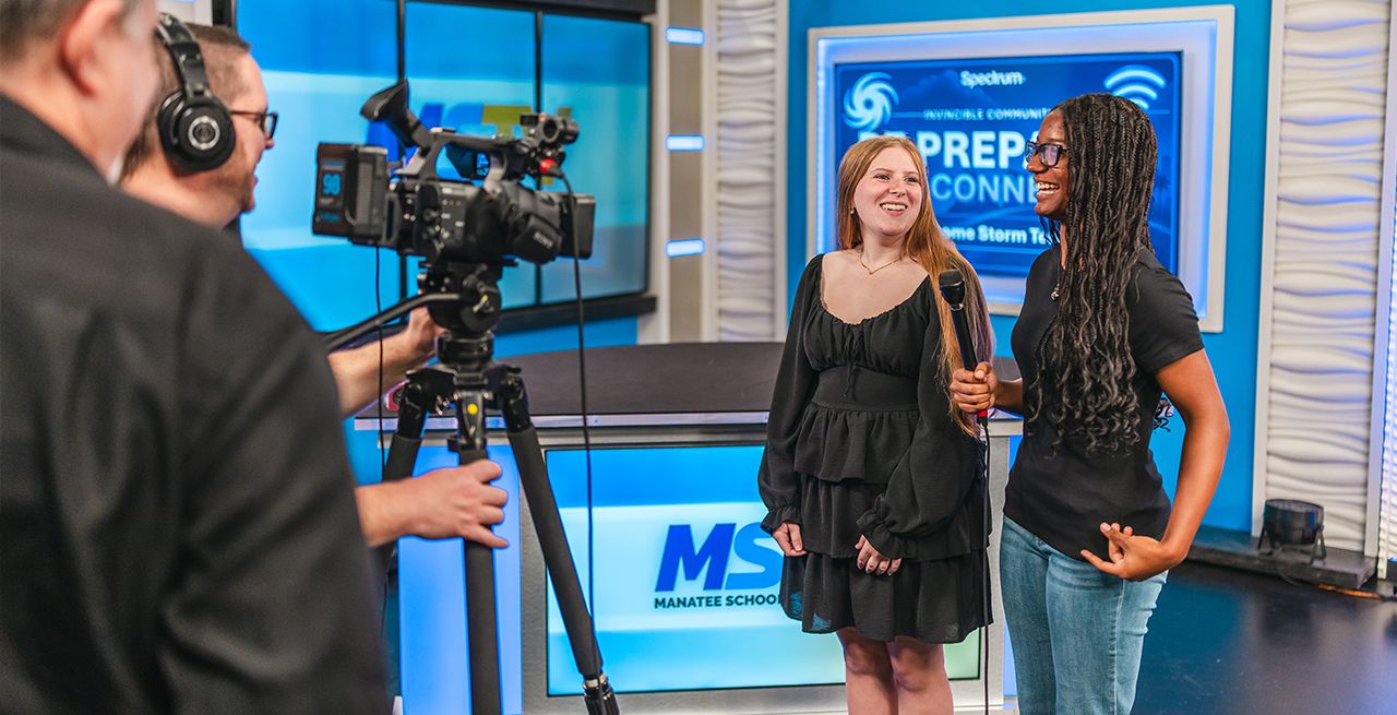 Two college students on camera in a TV studio