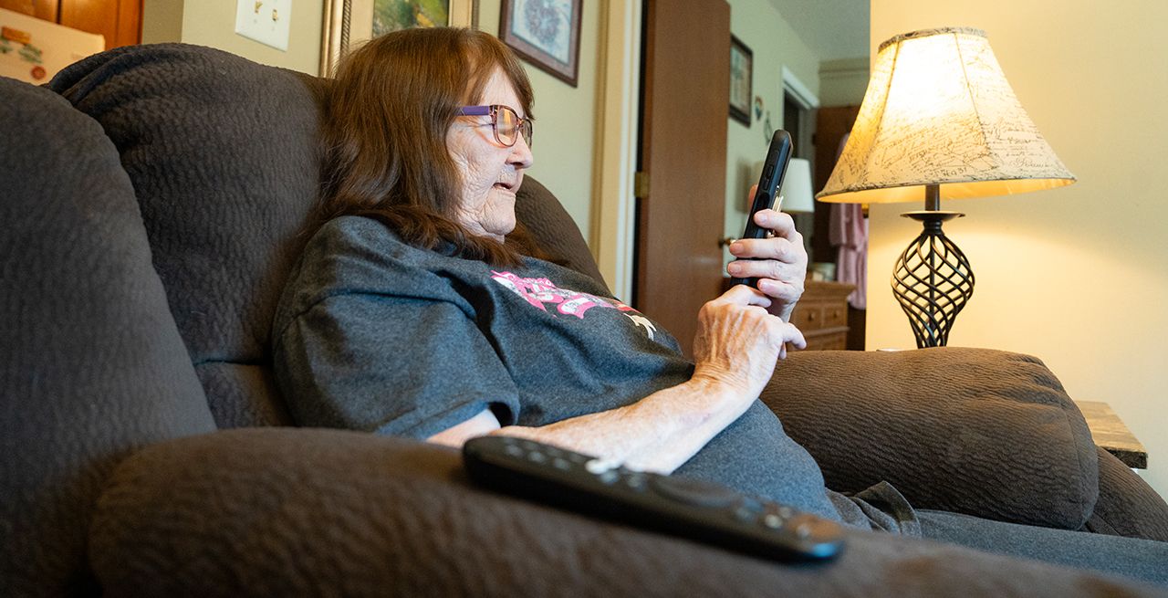A senior using her phone in her apartment