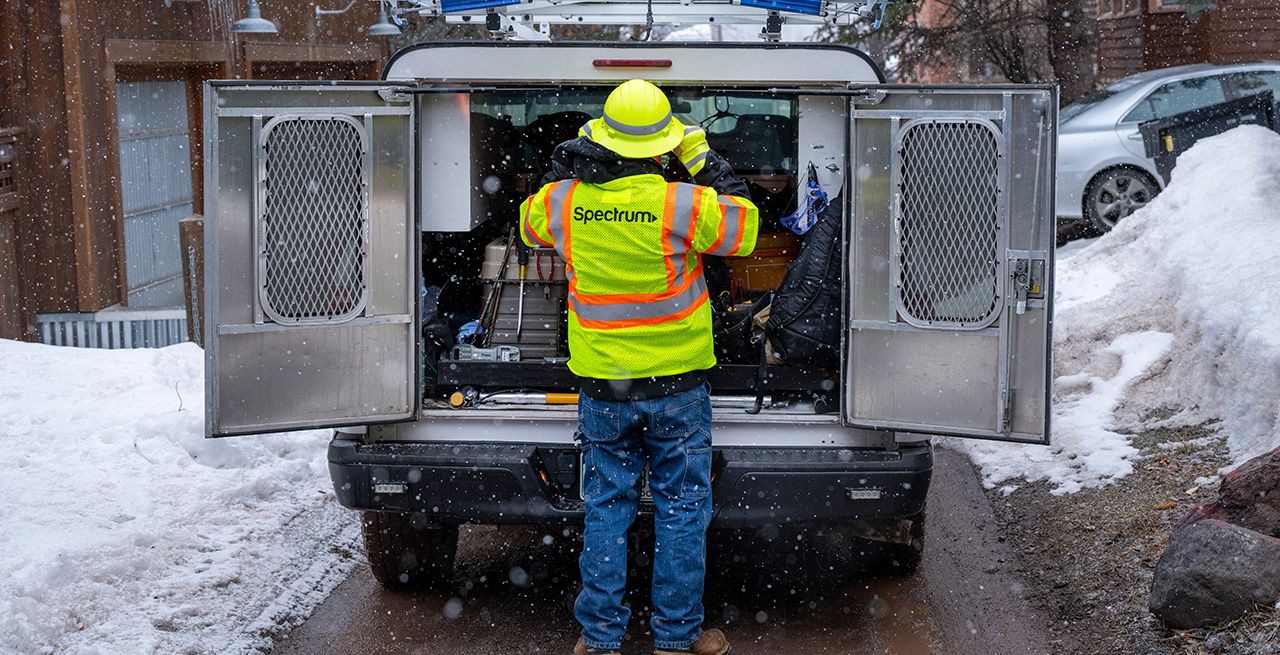 A Spectrum technician working on a broadband expansion project
