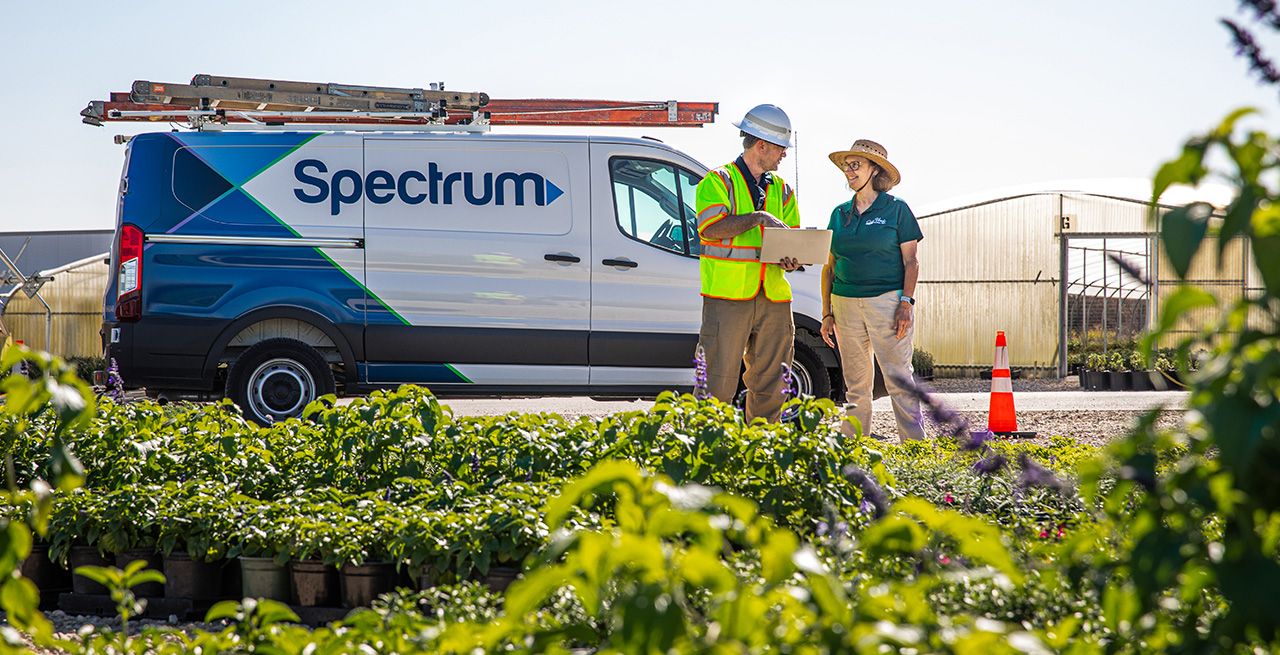 A Spectrum technician speaking with a farmer during AG Month