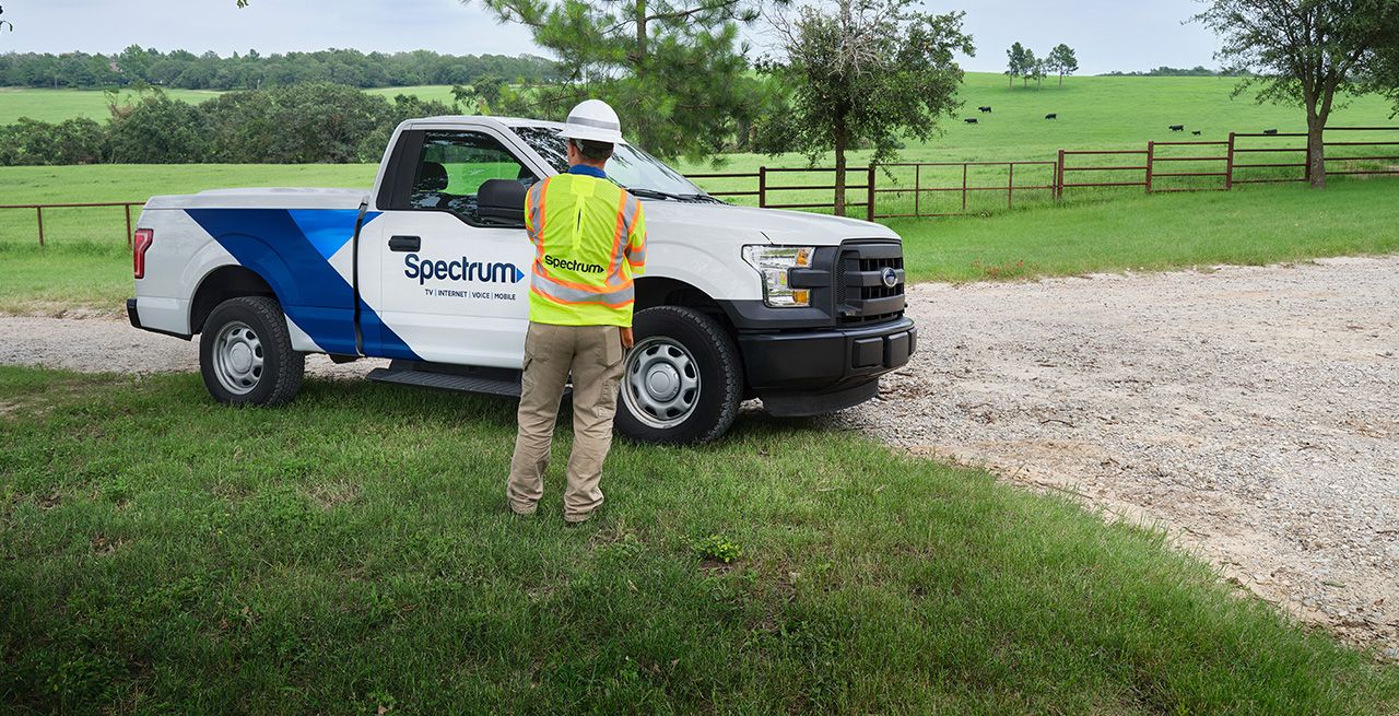 A Spectrum technician surveying a broadband expansion site