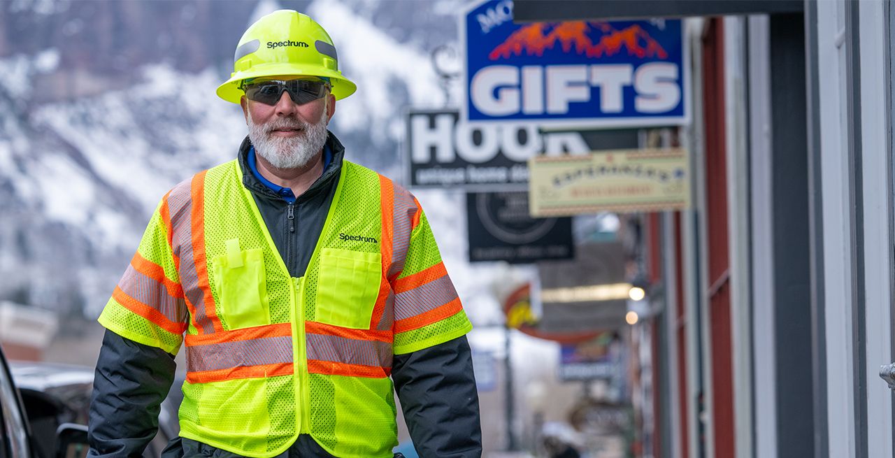 Spectrum technician walks through downtown Telluride, past shops and businesses