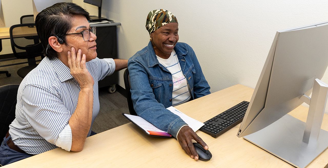 Adult student and her instructor in a computer lab during a Spectrum Digital Education class