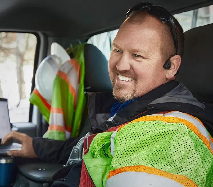 A Spectrum technician sitting in his truck, smiling