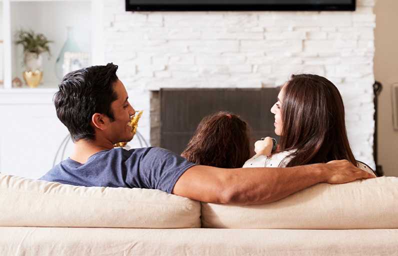 Happy family watching TV in their living room
