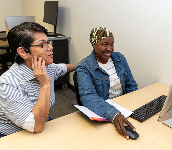 Adult student and her instructor in a computer lab during a Spectrum Digital Education class