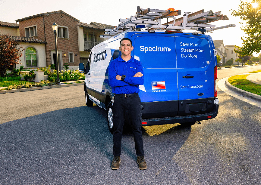 spectrum employee smiling arms crossed behind van