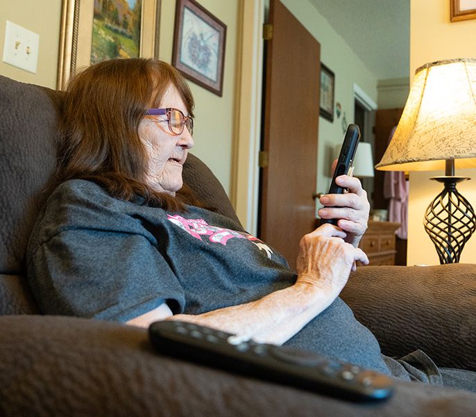 A senior using her phone in her apartment