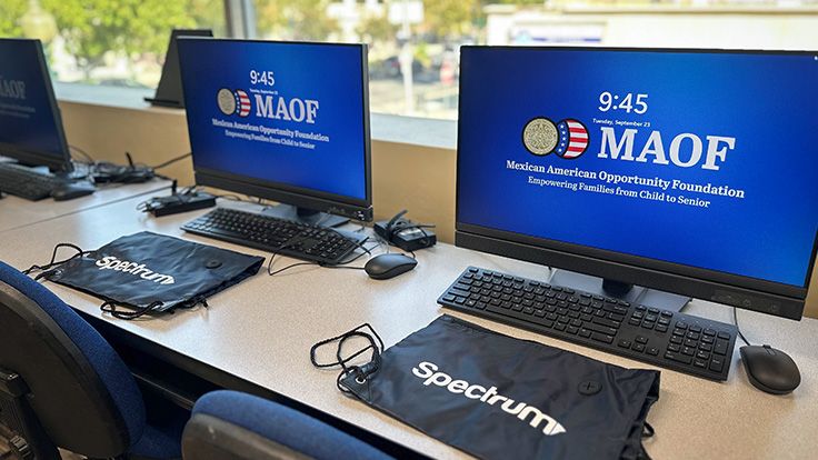 Desktop computers in a computer lab with MAOF logo on screens