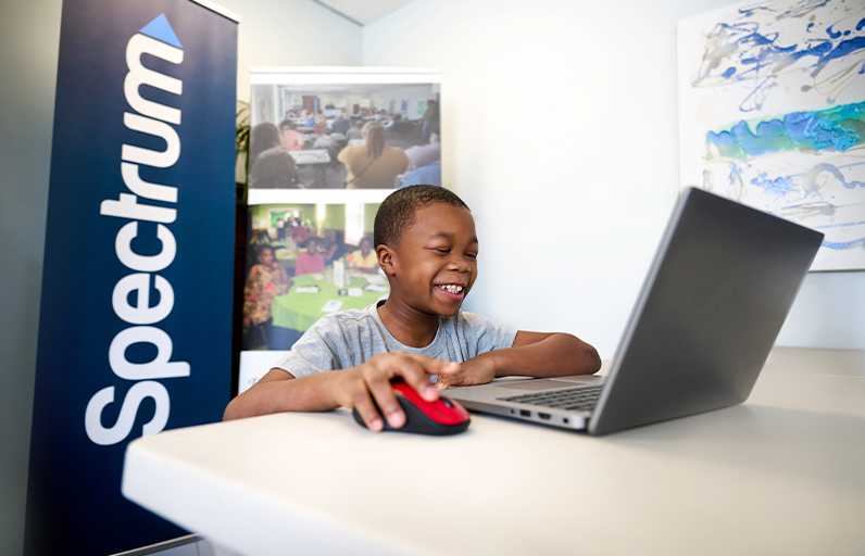 A child using a laptop smiling