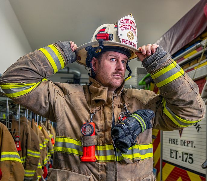 A fireman putting on his hat