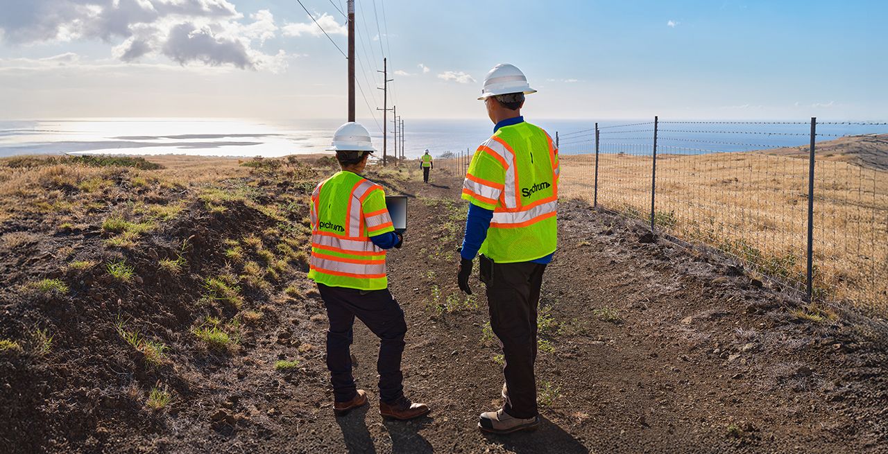 A pair of Spectrum field technicians surveying an area for broadband expansion