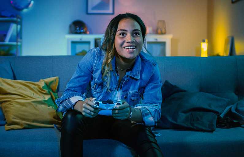 A gamer on her couch with controller