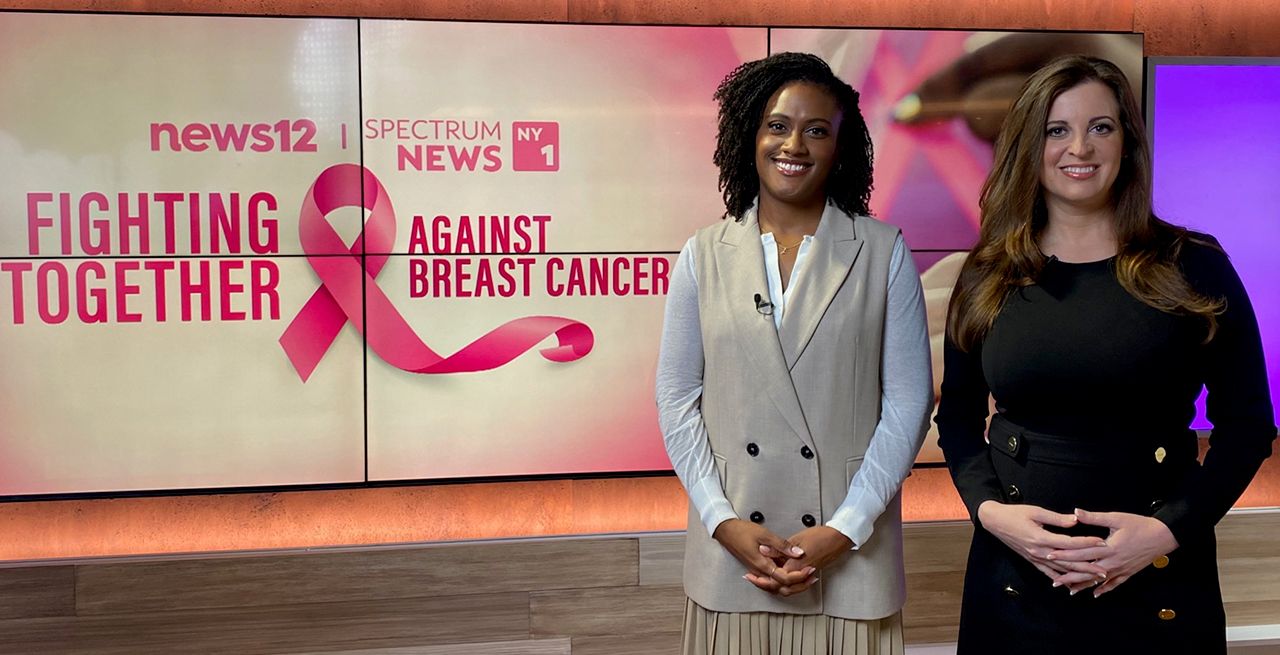 Spectrum News NY1 anchors in the studio with Fighting Together Against Breast Cancer ribbon logo in background 