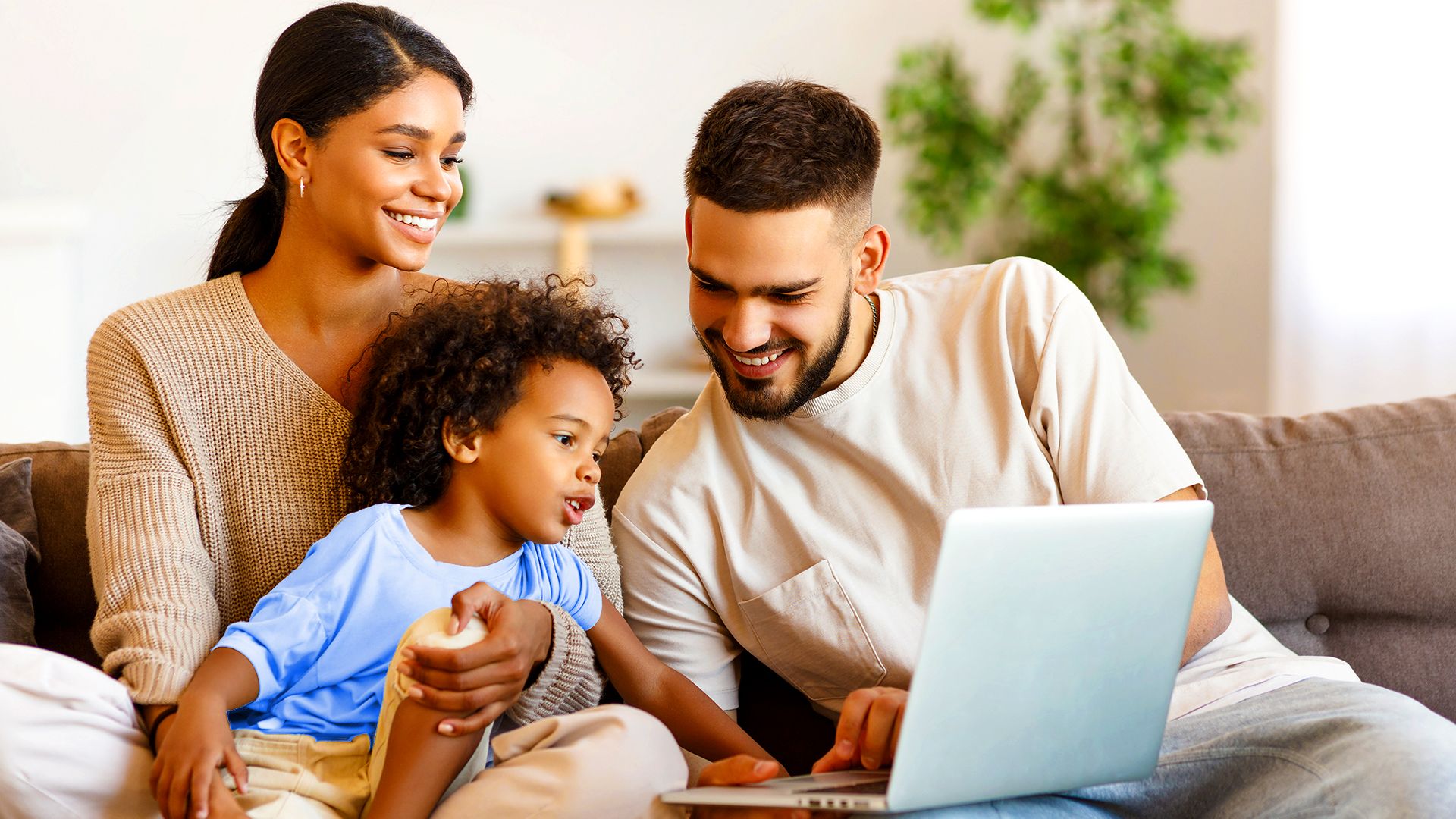 Family on couch using laptop