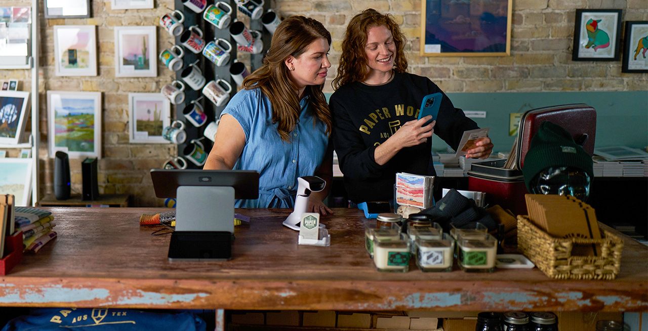 Small business owners behind the counter using their device