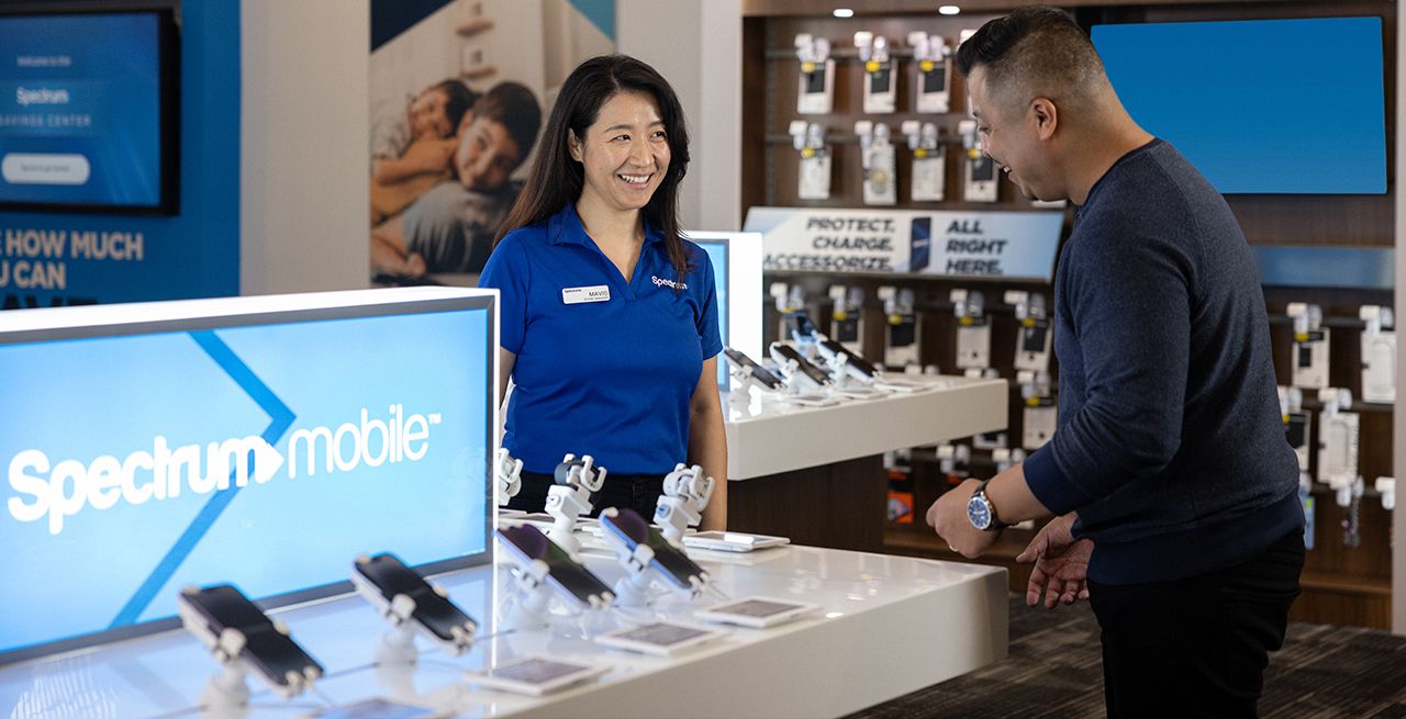 Spectrum employee assisting customer with mobile purchase.