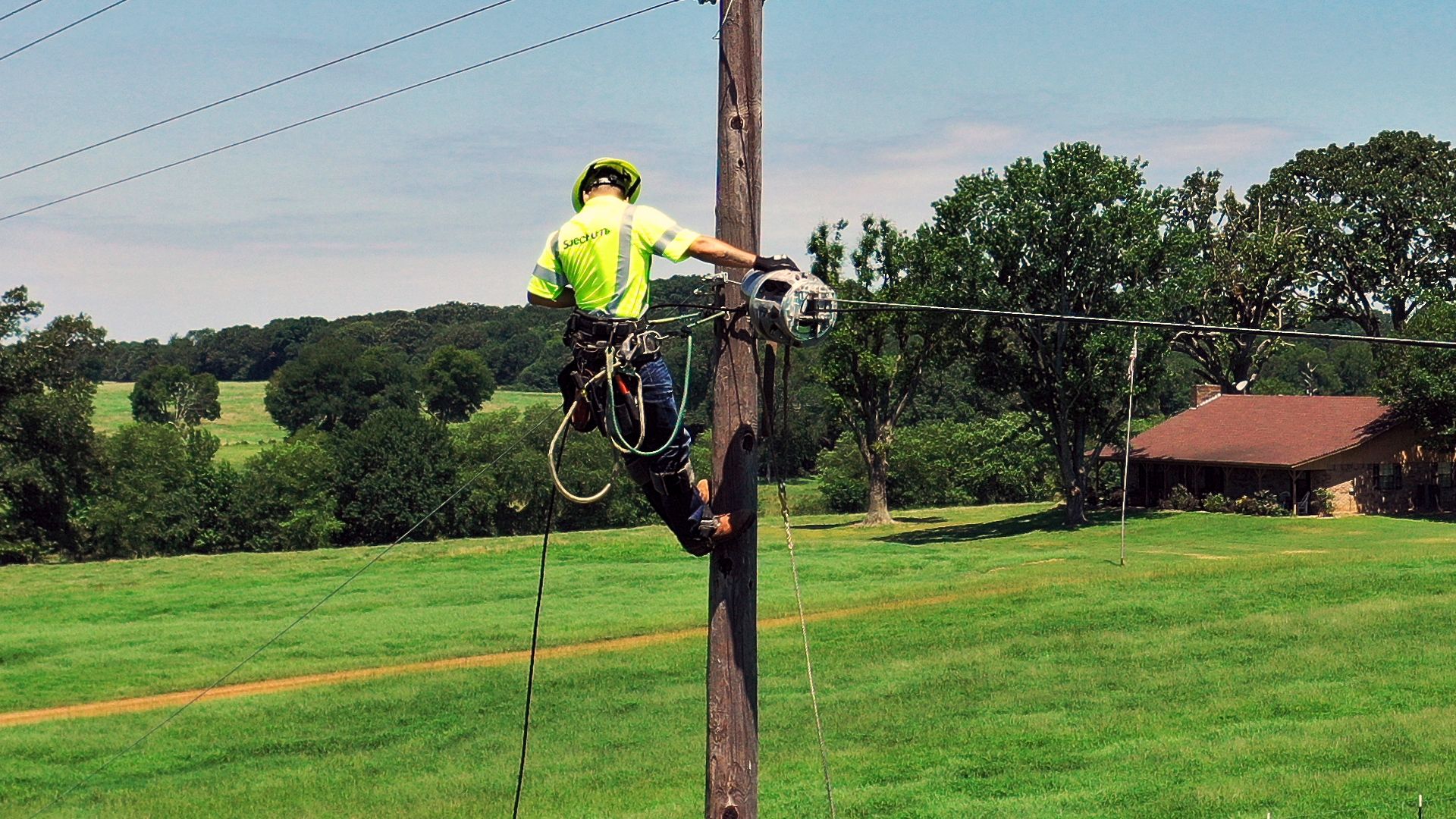 Spectrum field technician on a pole
