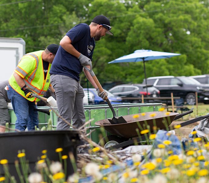 Spectrum volunteers gardening at a community center event